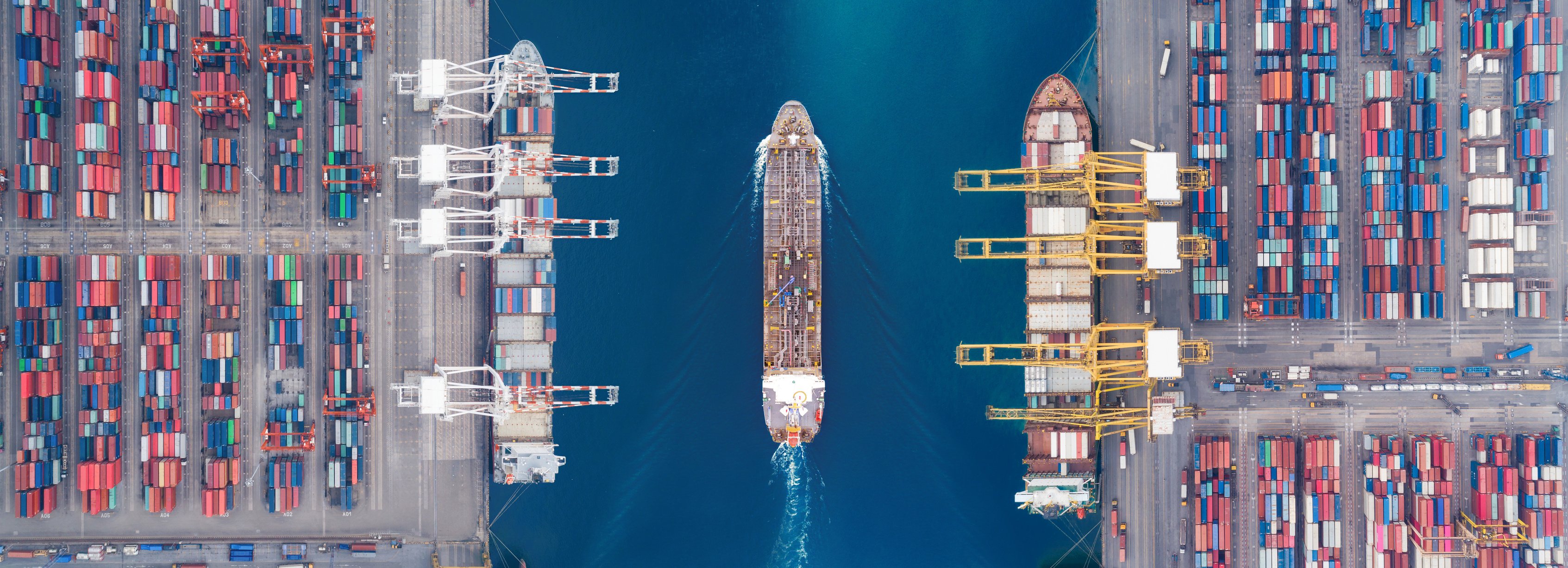 Aerial view panoramic oil tanker moving pass sea port warehouse and container ship or crane ship working for delivery containers shipment. Suitable use for energy power or transport or import export to global logistics concept.